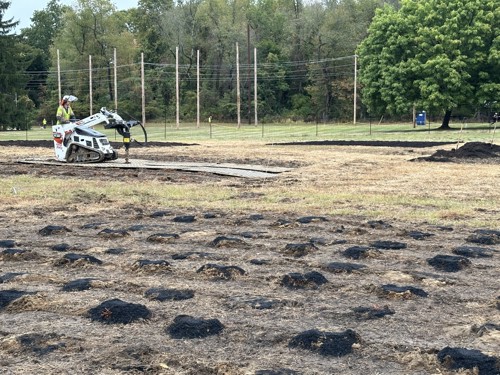Davey employee using a machine to apply vertical mulching treatments within the compacted soil area.